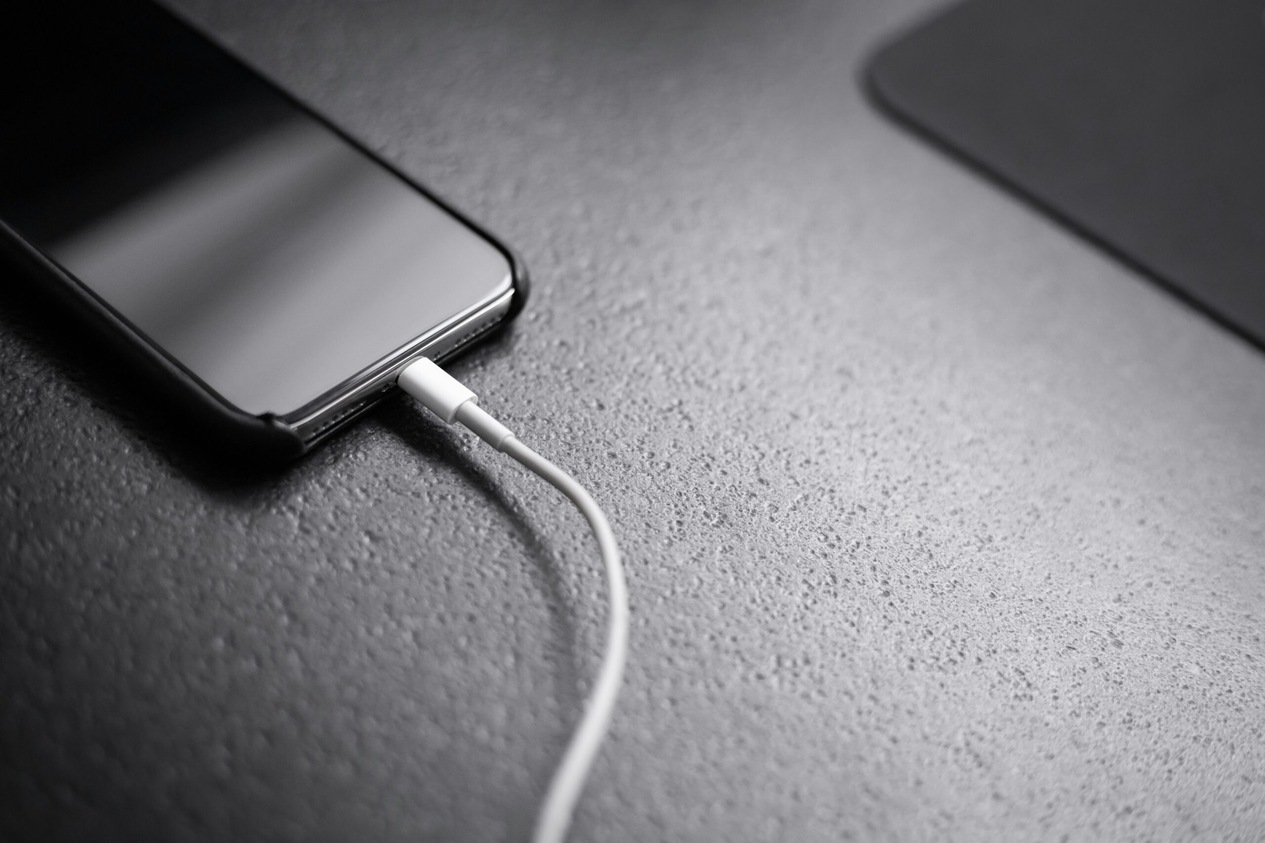 An iPhone connected to a charging cable